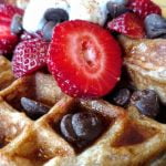 vegan sourdough waffle with syrup, strawberries, chocolate chips