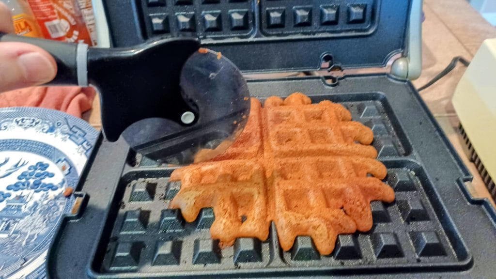 cutting vegan gingerbread waffles with pizza cutter
